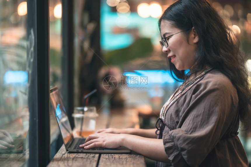 成功年轻的在咖啡店用笔记本电脑咖啡杯和智能手机如背景通信概念等工作的女散校对Portnoyunorg亚洲图片