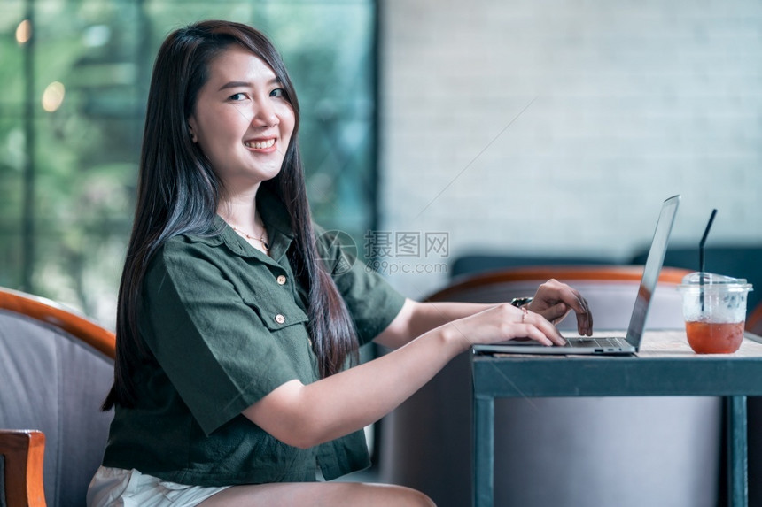 在咖啡店用笔记本电脑咖啡杯和智能手机如背景通信概念等工作的女散校对Portnoyunorg企业家吸引人的女士图片