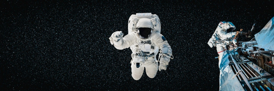 空域宇宙航员太空人在为外层间的站工作时进行太空走宇航员穿着全套太空服进行操作背景图片