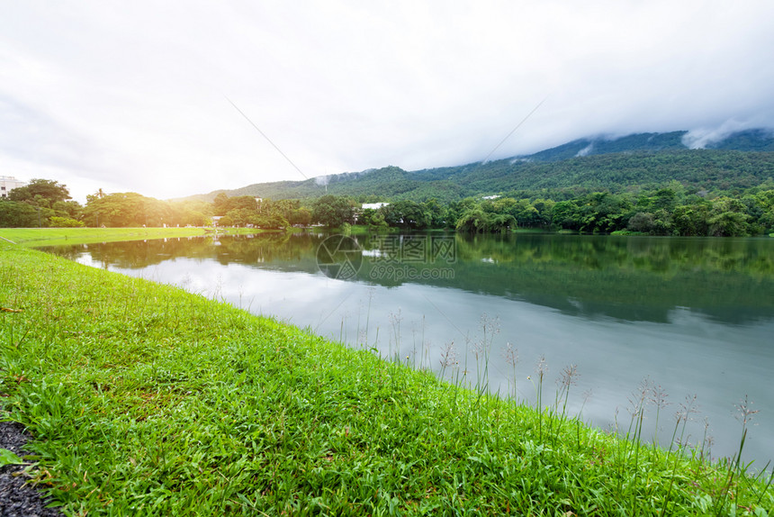 地平线AngKaew清迈大学自然森林中的绿草地湖景观山蓝天与白云的春背景池塘场图片