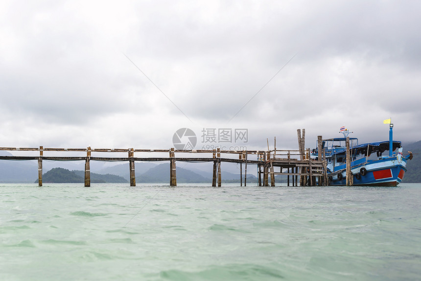 海浪船靠在旧木头上的船等待游客而雨云正在形成为了运输图片