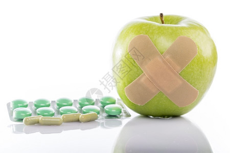 药片和创可贴绿色苹果配有护身符和药丸绿色苹果白底带护身符和药丸甜点营养植物背景