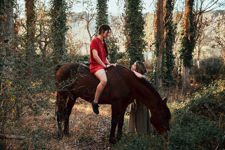 服用编织两个女朋友聊天骑着马乘兜风穿过农村的乡间动物图片