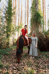 服用小路两个女朋友聊天骑着马乘兜风穿过农村的乡间春天图片