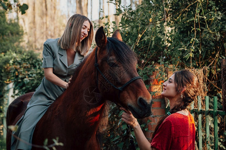 幸福两个女朋友聊天骑着马乘兜风穿过农村的乡间动物图片