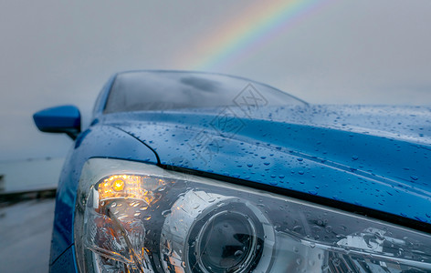 等雨停运动雨天停在海边附近的蓝色豪华车前视线彩虹是的背景车帽的蓝色布质上雨滴在恶劣天气下打开灯光以安全驾驶车辆风暴背景