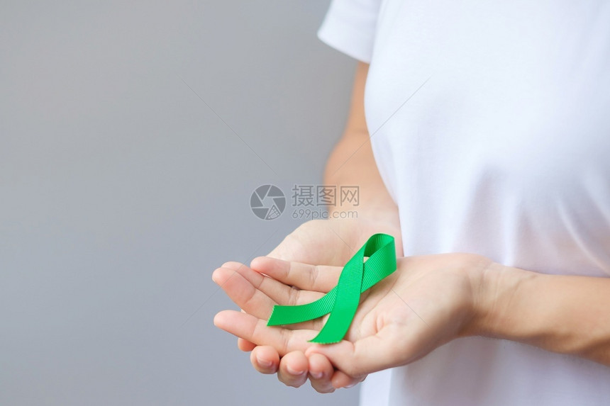 手拿绿丝带预防癌症概念图片