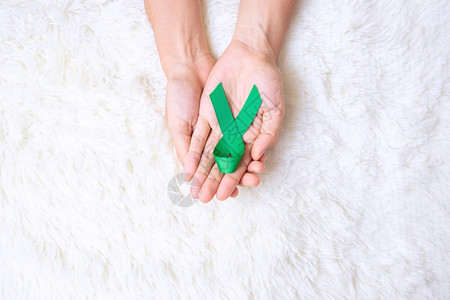 手拿绿丝带预防癌症概念图片
