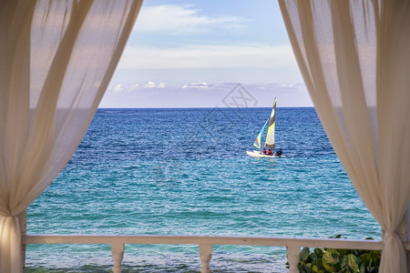 天水古巴大西洋沿岸航行的帆船浪漫景象有白色窗帘的拱顶阳台游艇背景图片