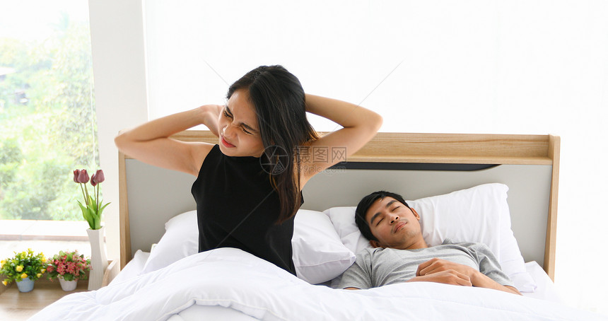 快乐的钟亚洲情侣睡在床上醒来的亚洲情侣早上完全休息晨图片