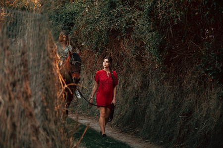 马术黑发追踪两个女朋友聊天骑着马乘兜风穿过农村的乡间图片