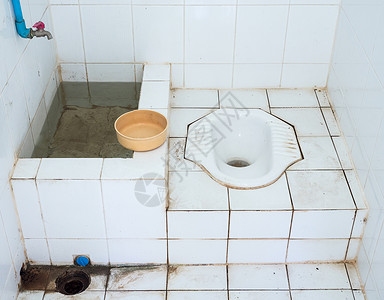 农村老的恶心在泰国乡村边小寺庙内用塑料水碗的肮脏公共厕所和塑料水壶图片