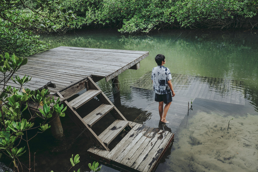 生活女孩在美丽的红树林中亚洲男子湖边度假时间河图片