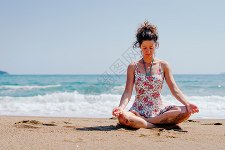 依帕内玛海滩夏服女青年在海边滩或做瑜伽冥想在阳光明媚的白天拉伸冥想放松莲花的位置合十礼正念体式背景
