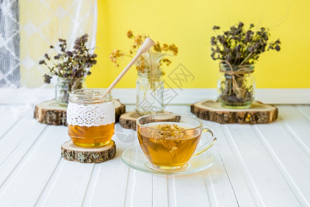 碟子一杯热茶木桌和园背景一杯热茶木桌上麻布草本植物图片