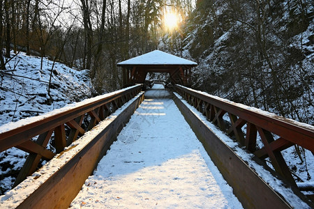 水公园美丽的雪木桥有一条长途徒步的漫道路冬季与雪和太阳一起过冬天图片