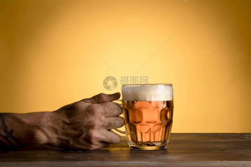 拿着玻璃啤酒木桌的人高分辨率照片质量男人优的酒吧图片