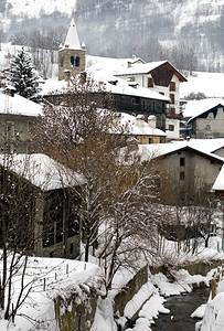 一个小山村在大雪降后意利冬天溪流明尼斯图片