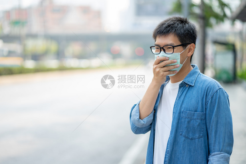 城市里佩戴口罩防止污染的男性肖像图片