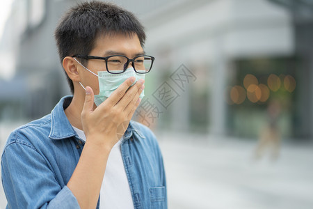 户外戴口罩防止污染的男性图片