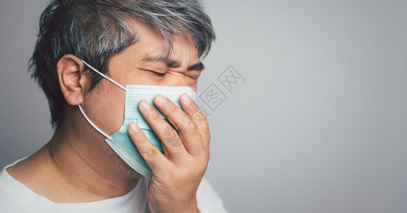戴口罩的咳嗽的中年男性图片