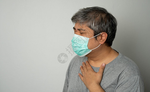 戴医疗口罩的咳嗽的中年男性肖像图片