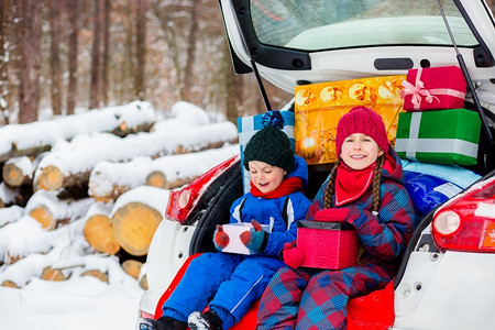 摩托车尾箱假期户外快乐的孩子享受许多圣诞礼物在车尾箱里寒冷的冬天雪气快乐的孩子享受许多圣诞礼物在车尾箱里人们背景