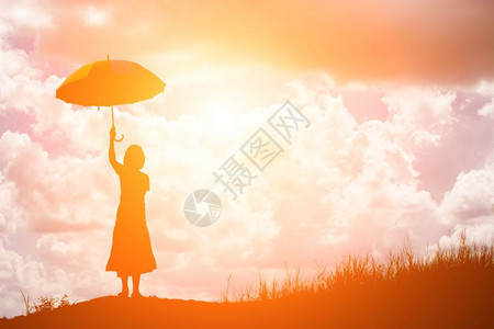 自然思维复制在美丽日落时独自在田野站着的女雨伞郎图片