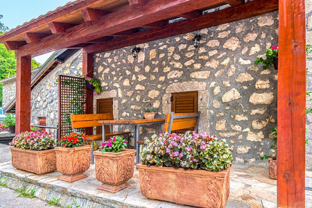 长椅家木制的桌边和长凳附近的花朵以在黑山的梯田上放松地貌图片