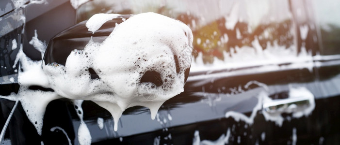 男人汽车采用活泡沫肥皂商业清洁洗服务概念进行户外洗车工作图片