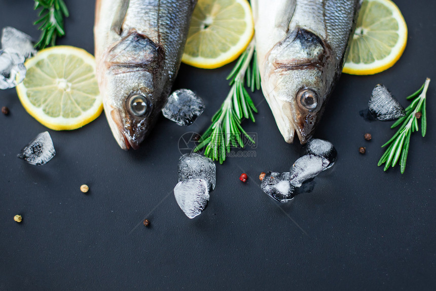 食物黑石板上的生鱼鲈配香料和草新鲜的鲈鱼顶视图带复制空间蔬菜烹饪图片