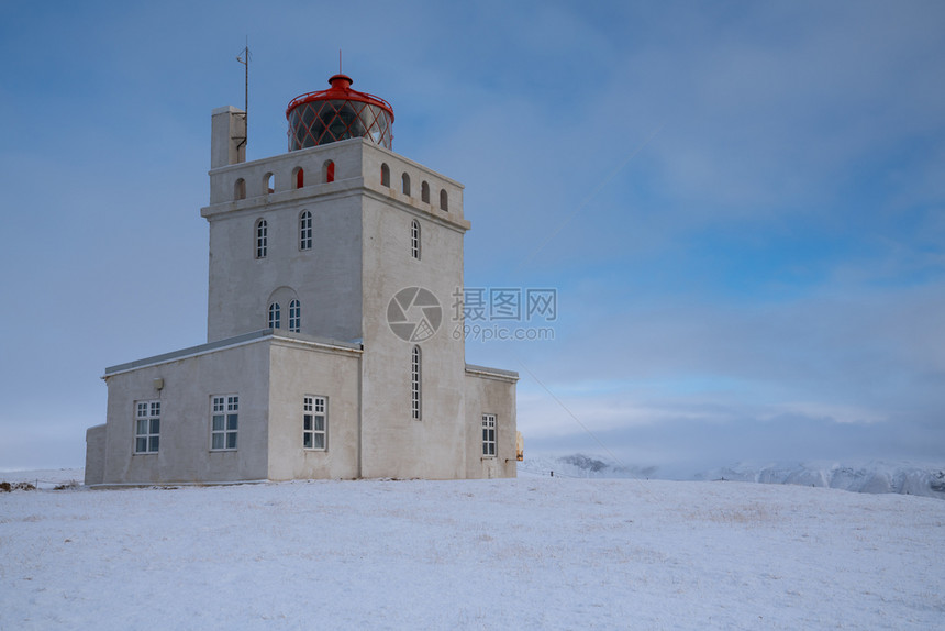 自然半岛Dyrholaey角灯塔全景图像冰雪和清晨光照冰岛冬季日出图片
