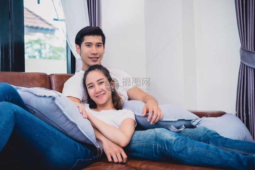 美丽的妻子亚洲年轻夫妇放松对沙发情侣和概念的爱人和情侣概念蜜月与婚礼主题内地与约会主题微笑图片