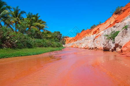 风景红色的沙丘与丛林中小溪峡谷之间的红河慕内越南东亚仙女图片