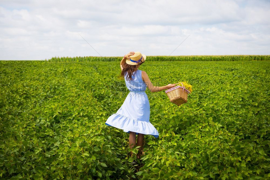 户外草地幸福蓝板上的美女站在绿色田野上蓝板的美女站在绿色田野上图片