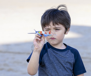 小男孩手拿玩具飞机图片