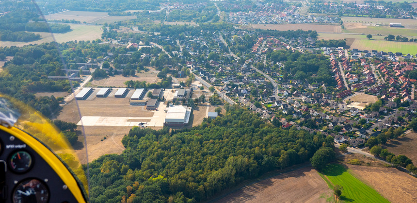 村庄机场从极光飞到德国郊区的景象包括近海田地草原森林和工业区俱乐部图片