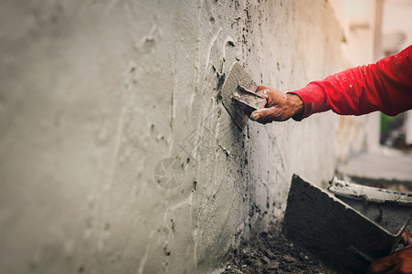 砂浆板泥水匠灌浆建筑工地房用墙上石膏水泥的工人手印抹灰背景