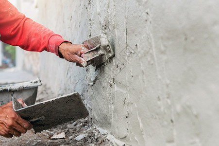 使固定抹灰建筑工地房用墙上石膏水泥的工人手印灌浆背景图片
