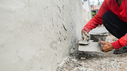砂浆板改进工作程建筑地房用墙上石膏水泥的工人手印背景