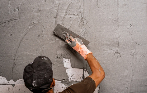 修理职业劳动建筑工地房用墙上石膏水泥的工人手印图片