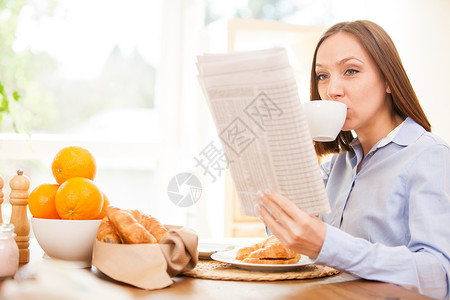 布朗特女商人在家吃早餐时正看报纸通讯成功的衬衫图片