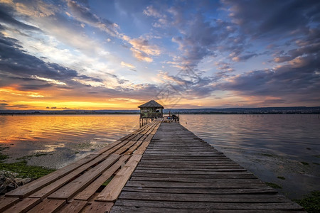 湖边富饶多彩的长地貌湖边有木头码和小房子丰富多彩的日落惊人图片