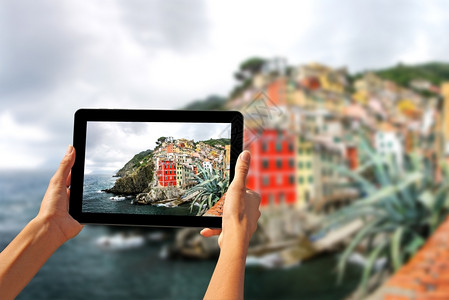 意大利五渔村里奥马焦雷在平板电脑上拍照的女孩快利古里亚海岸图片