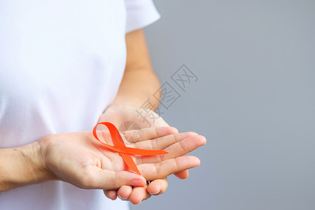 手拿橙丝带预防癌症概念图片