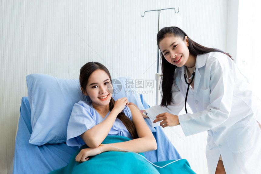年轻女医生用注射器向女病人注射盐水图片