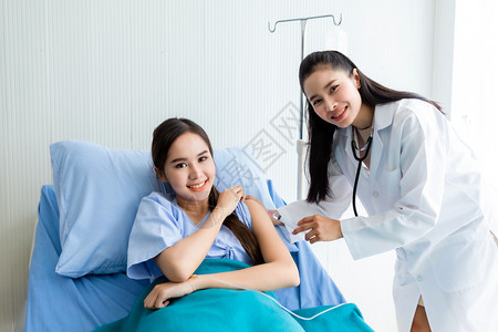 年轻女医生用注射器向女病人注射盐水图片