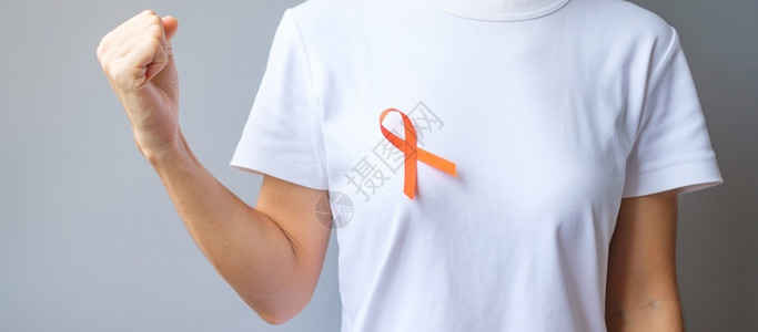 胸口佩戴橙丝带的男人预防癌症概念图片