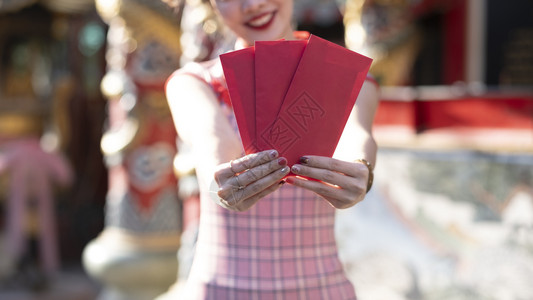 哆啦A传统的庆祝给予幸福亚裔女人拿着红包在月露新年给阿宝做安啦新年快乐的概念背景