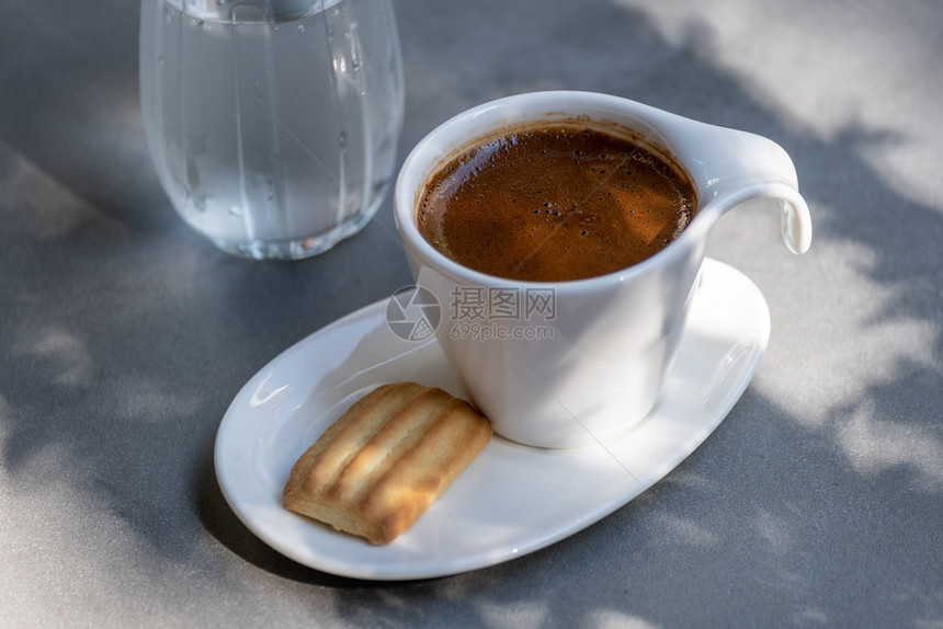 芳香种族的杯子土耳其传统咖啡杯配上一饼干和水在阳光明媚的一天供应杯咖啡图片
